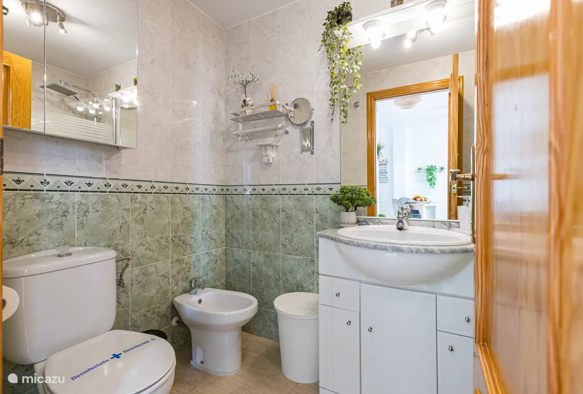 Salle de bain complète avec bidet, baignoire et douche, sèche-cheveux, miroir louppeur et trousse de premiers secours sous le lavabo.