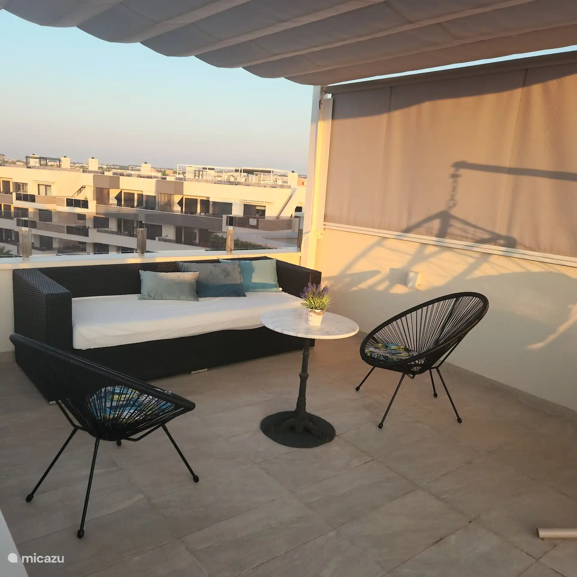 Sièges sur le toit-terrasse avec vue sur la piscine et la mer