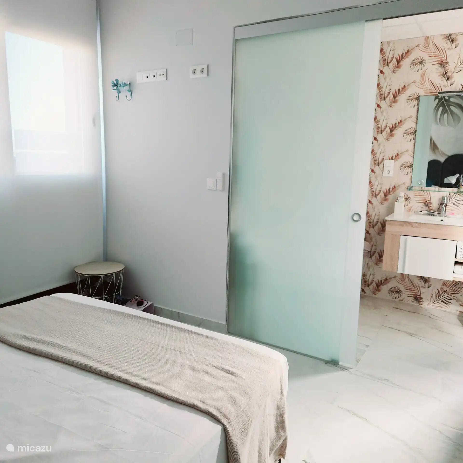 Chambre principale avec entrée dans une luxueuse salle de bains attenante avec douche à effet pluie et douchette