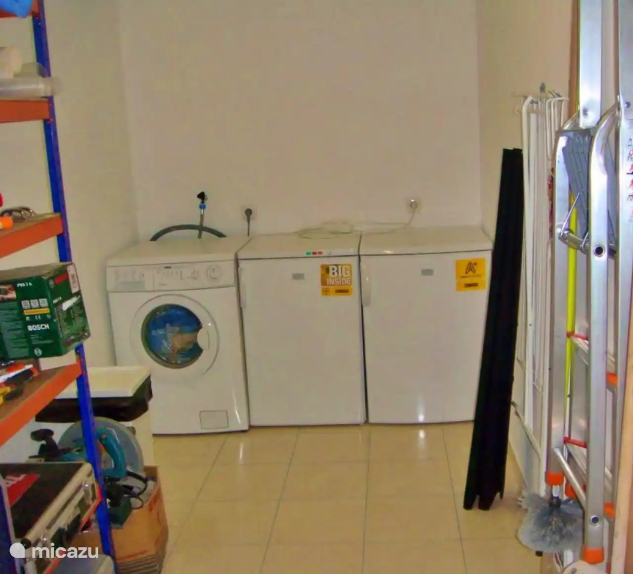 Unten im Abstellraum befinden sich Waschmaschinen sowie Kühl- und Gefrierschränke