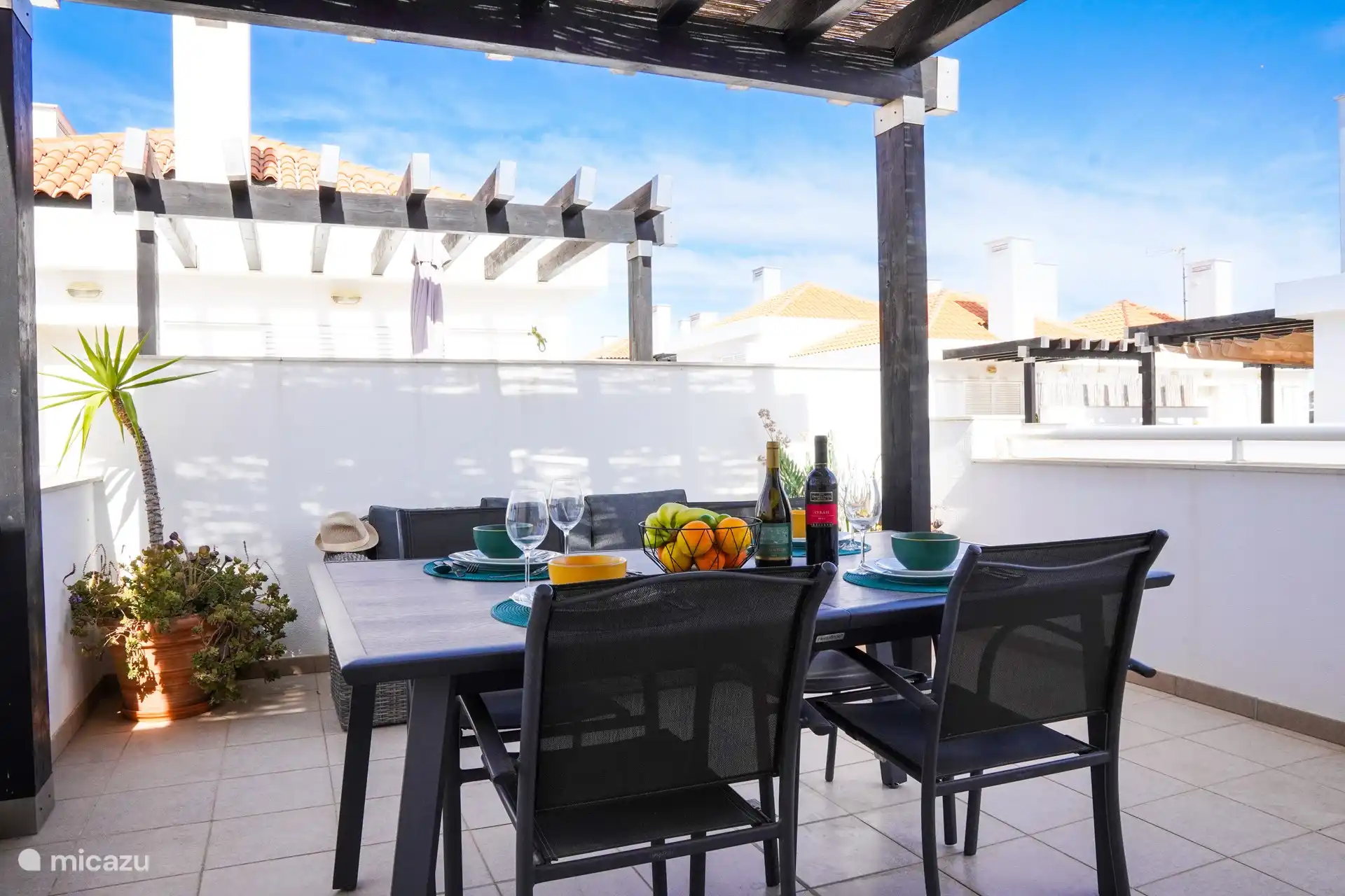 Große Dachterrasse mit Tisch und 4 Stühlen und einer Gartenbank. 