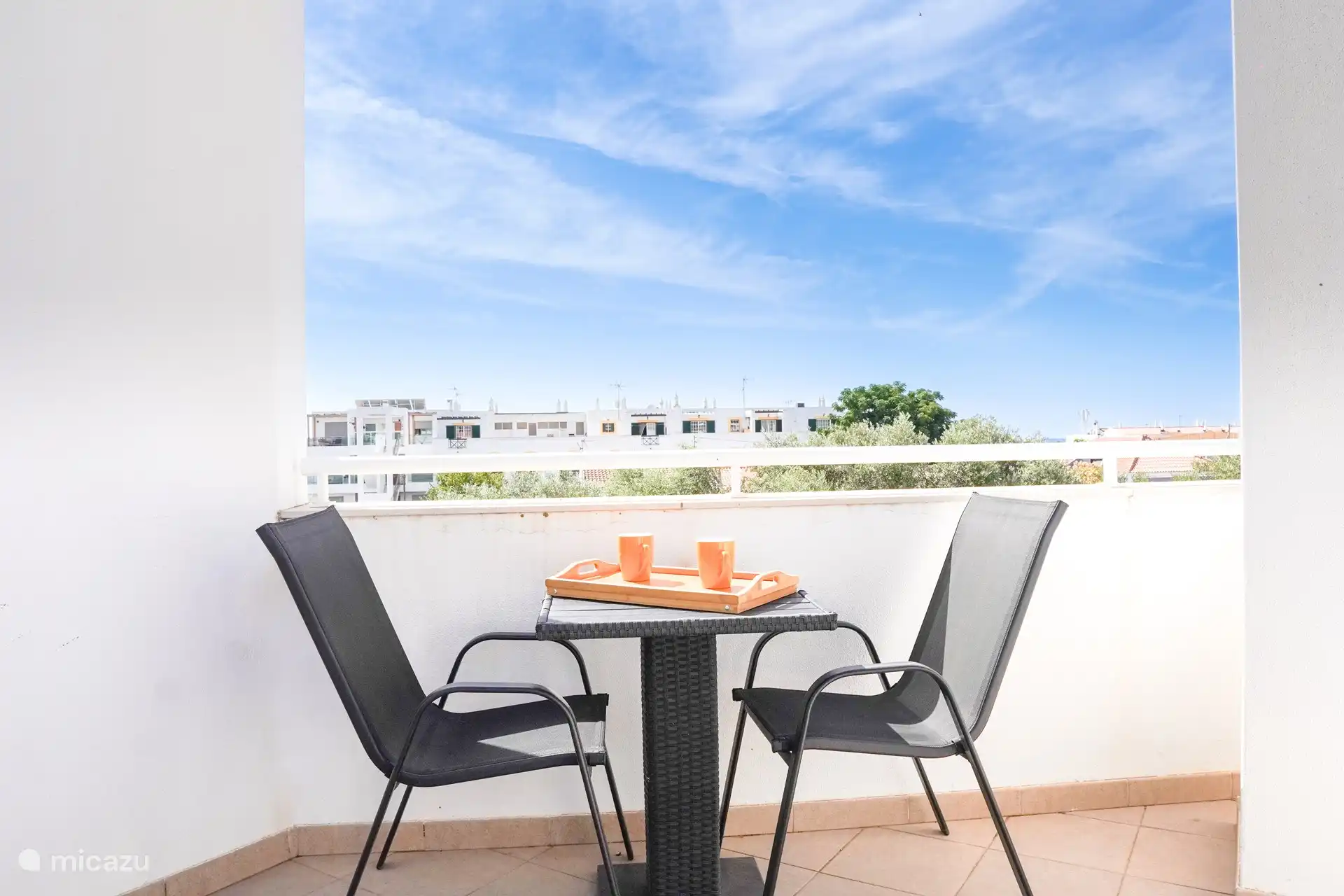 Kleine Dachterrasse mit Tisch und 2 Stühlen. 