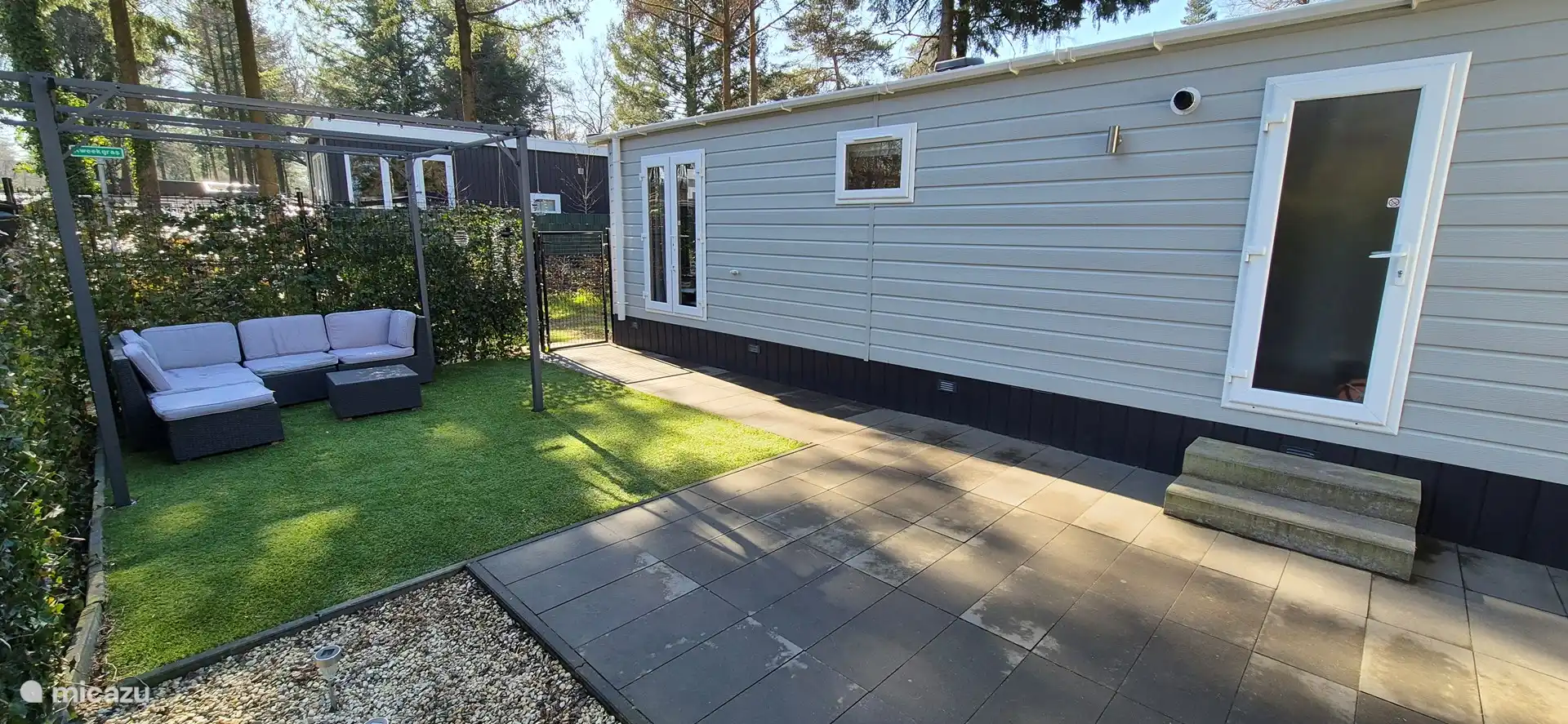 Maison de vacances à Hoenderloo avec terrasse ensoleillée et coin salon confortable.