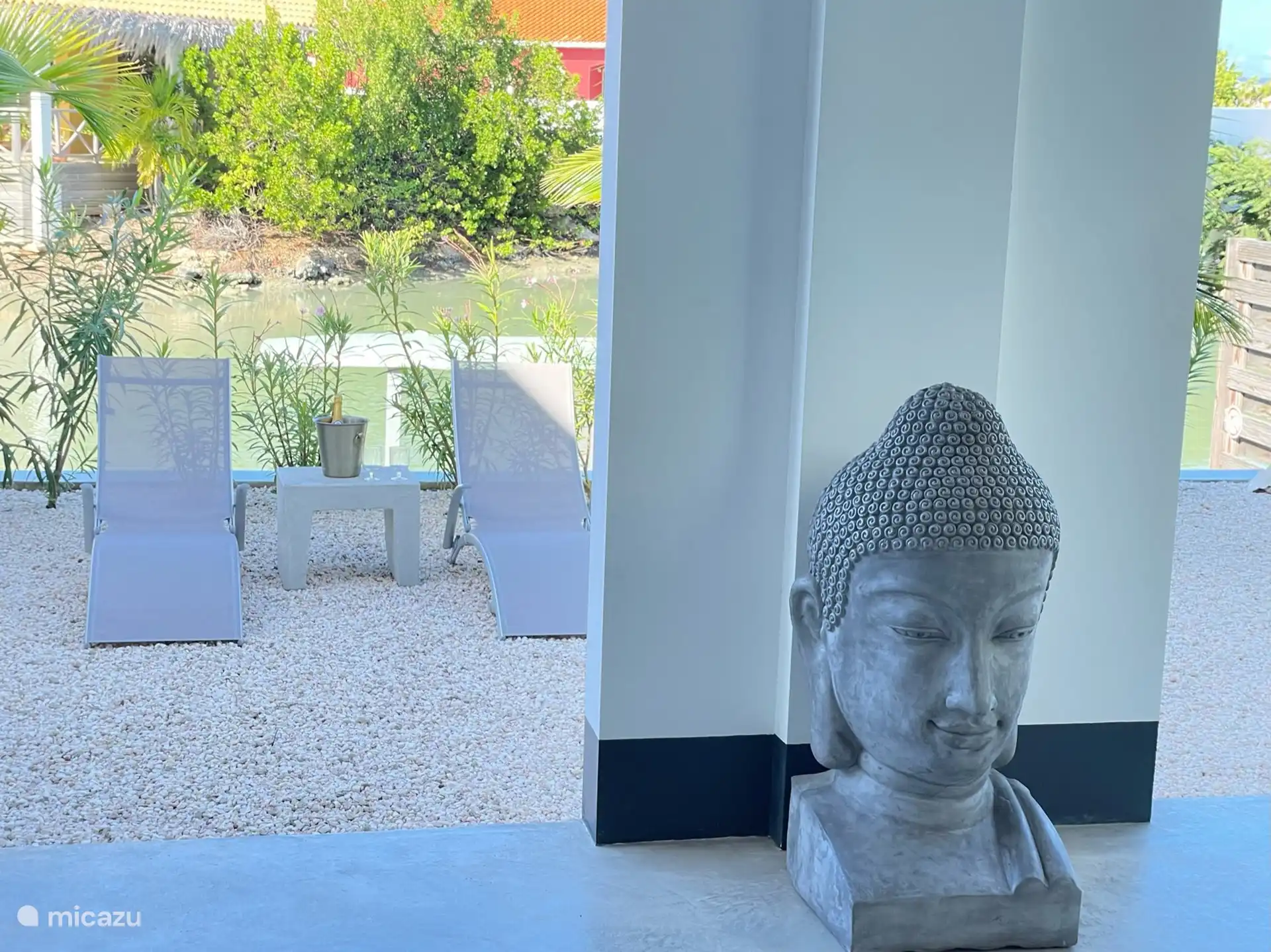 Vista del porche al jardín con tumbonas