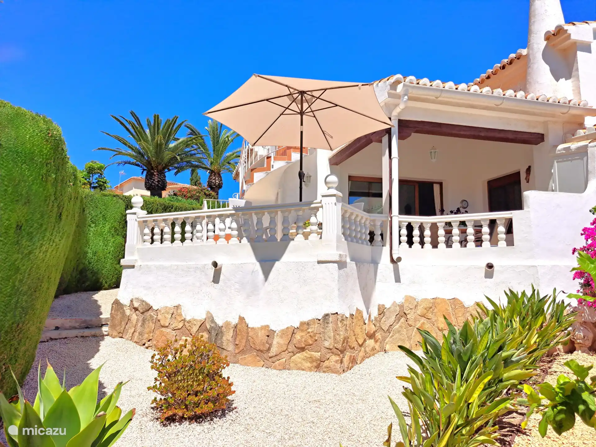L’arrière de la Casa Geco avec la terrasse ensoleillée, le jardin privé et les escaliers menant à la terrasse privée sur le toit.
