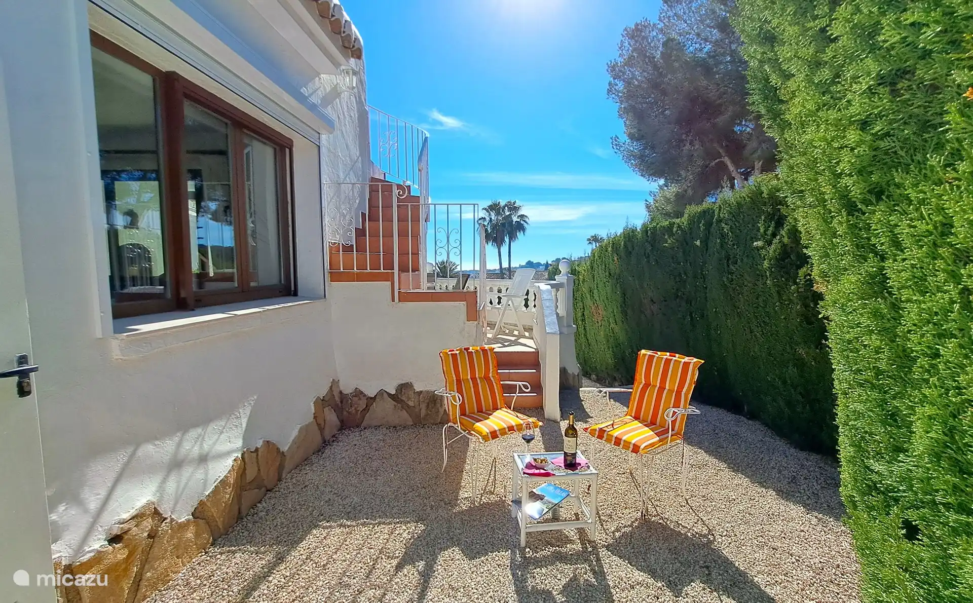 Endroit abrité sur le côté de la maison. En arrière-plan, les escaliers menant à la terrasse privée sur le toit.