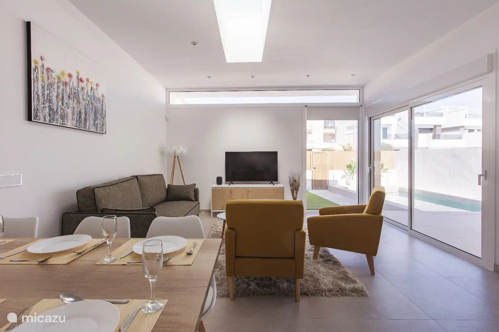 Acogedora sala de estar con vistas a la piscina y al jardín.