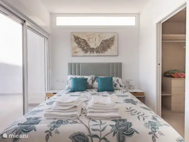 Villa la Vida - piscina (climatizada) en España, Murcia, Santiago de la Ribera - villa Dormitorio con baño en suite. Presentes: aire acondicionado con función de calefacción y refrigeración, vestidor, persianas opacas, caja fuerte y silla.