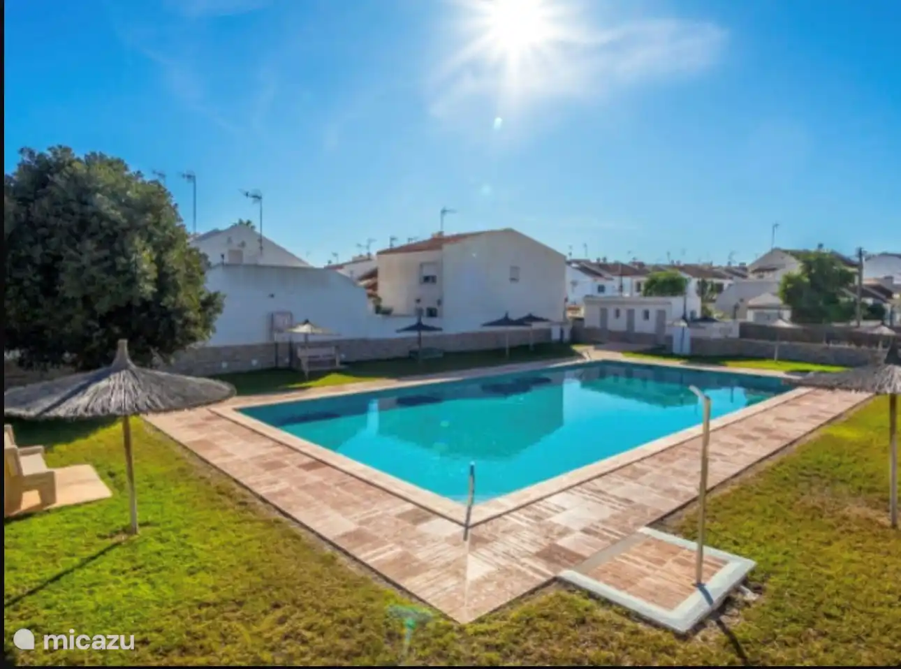 Piscina comunitaria con sombrillas 