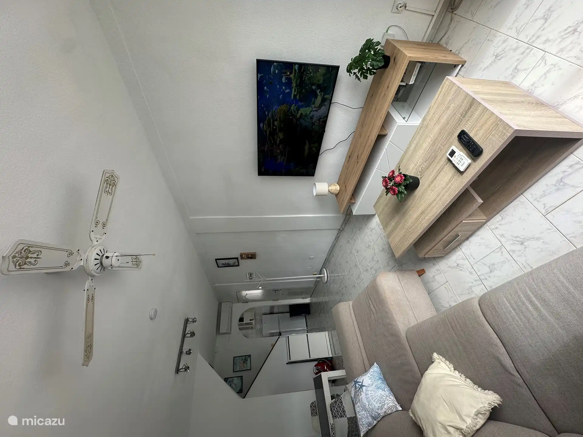 Sala de estar con mesa de comedor y aire acondicionado y la cocina 