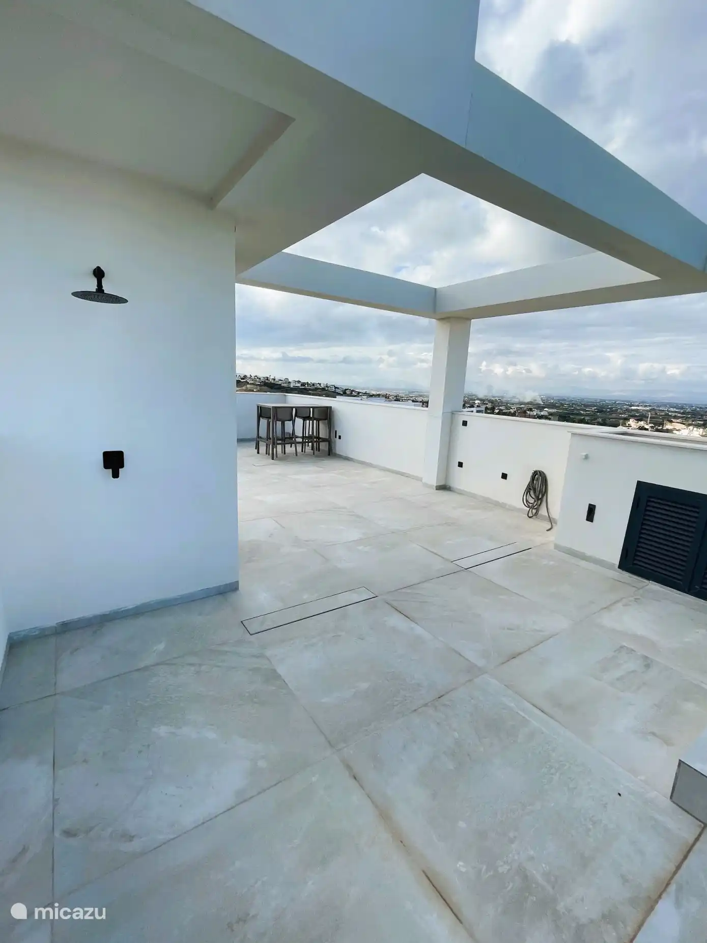 The spacious private roof terrace with private pool, seating area and dining area