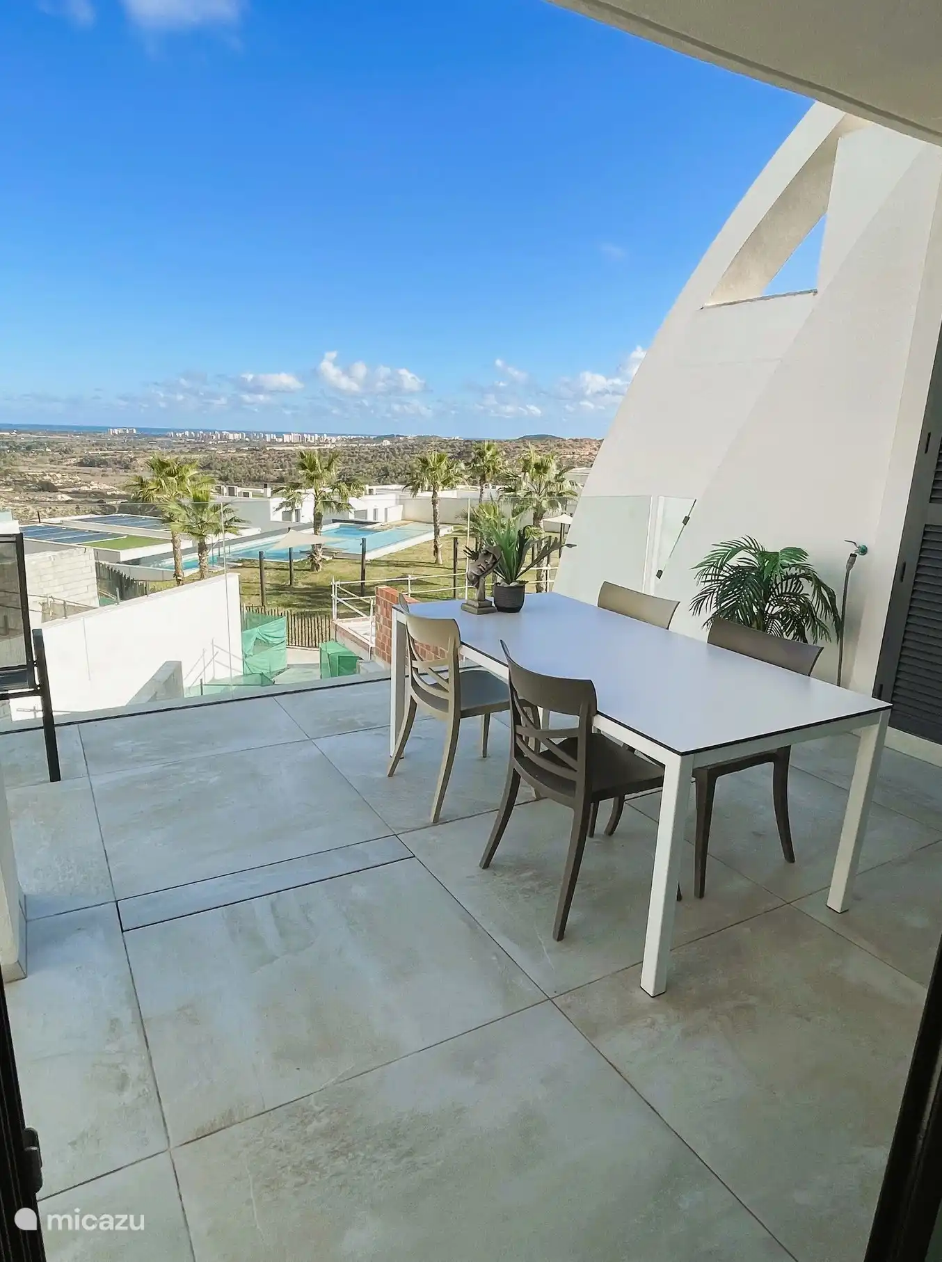Terrace off the living room with views of the complex and the sea in the distance