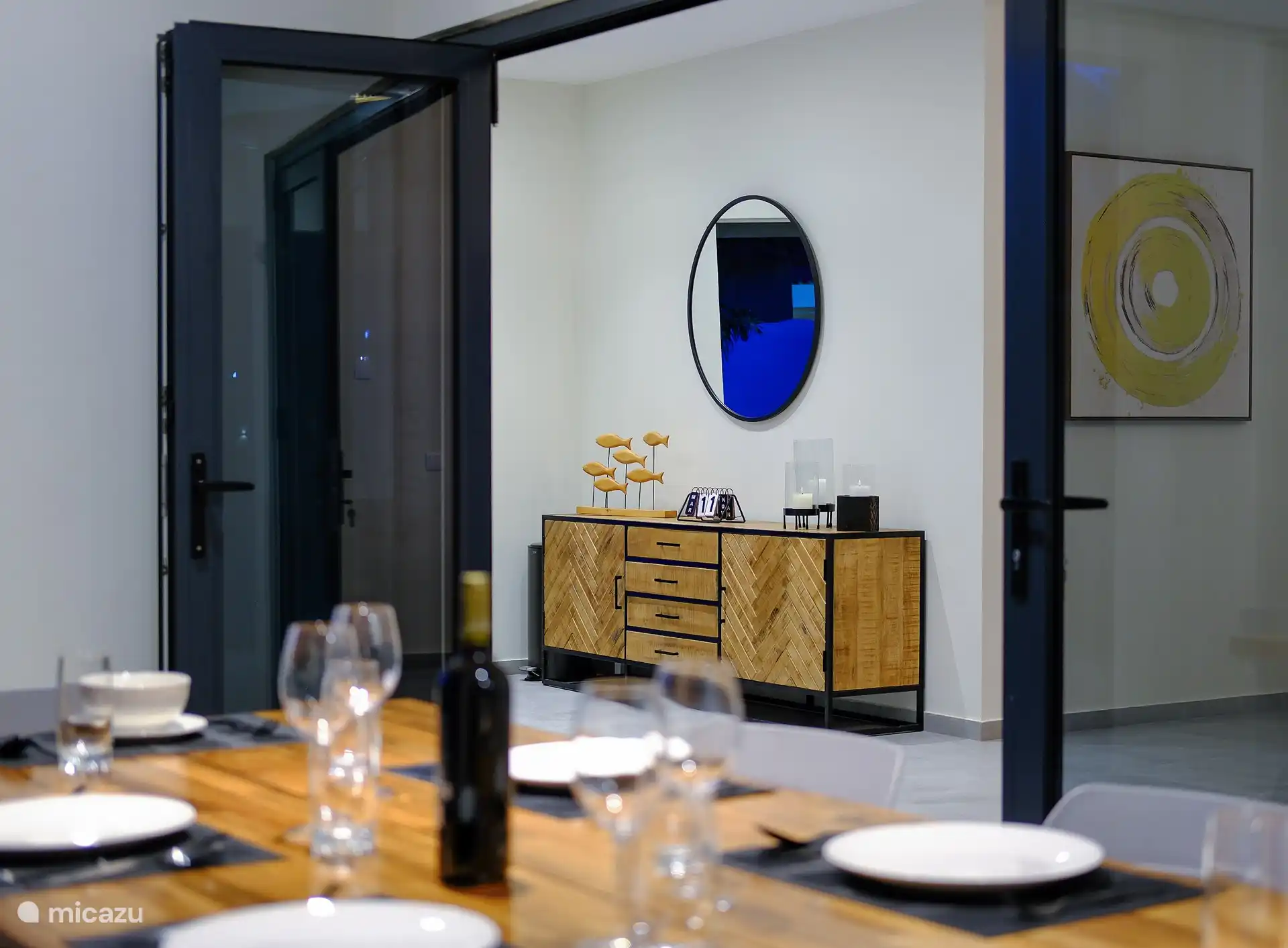 Table en bois spacieuse pour 6 personnes avec chaises modernes donnant sur la piscine