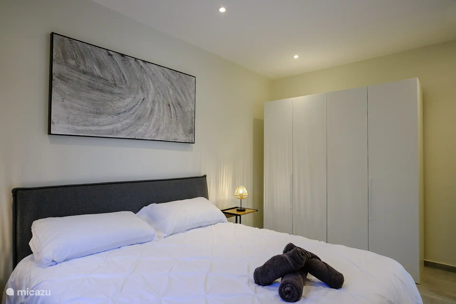 Chambre principale avec lit King size avec climatisation et grande armoire. Grand miroir, table à repasser/fer à repasser et sèche-cheveux également fournis