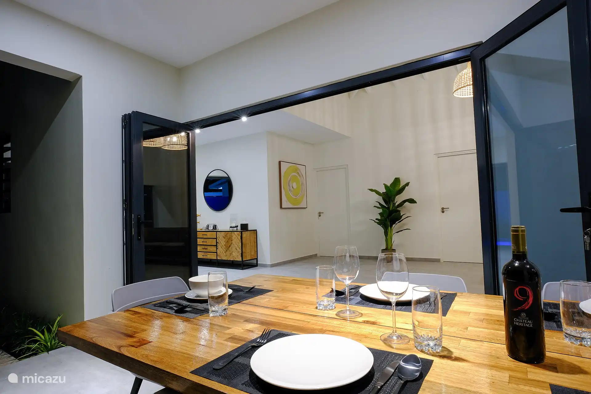 Table en bois spacieuse pour 6 personnes avec chaises modernes donnant sur la piscine