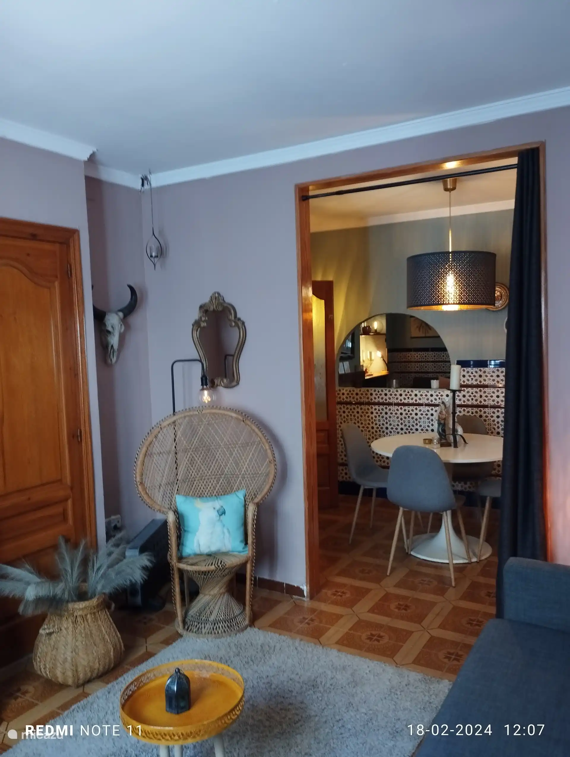 woonkamer 2 met T.V en zicht op eetkamer en door boog woonkamer 1