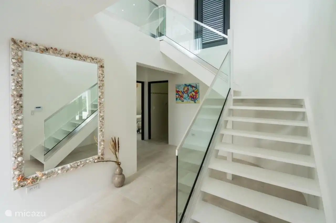 Zodra je de villa binnenkomt, loop je de trap op voor de woonkamer & keuken.