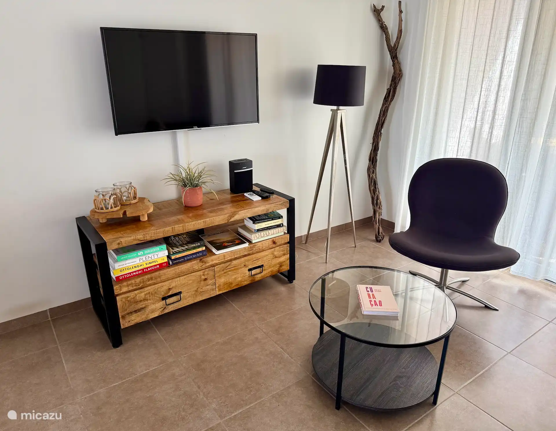 Er zijn verschillende boeken, een Bose muziekbox en een Apple TV aanwezig. 