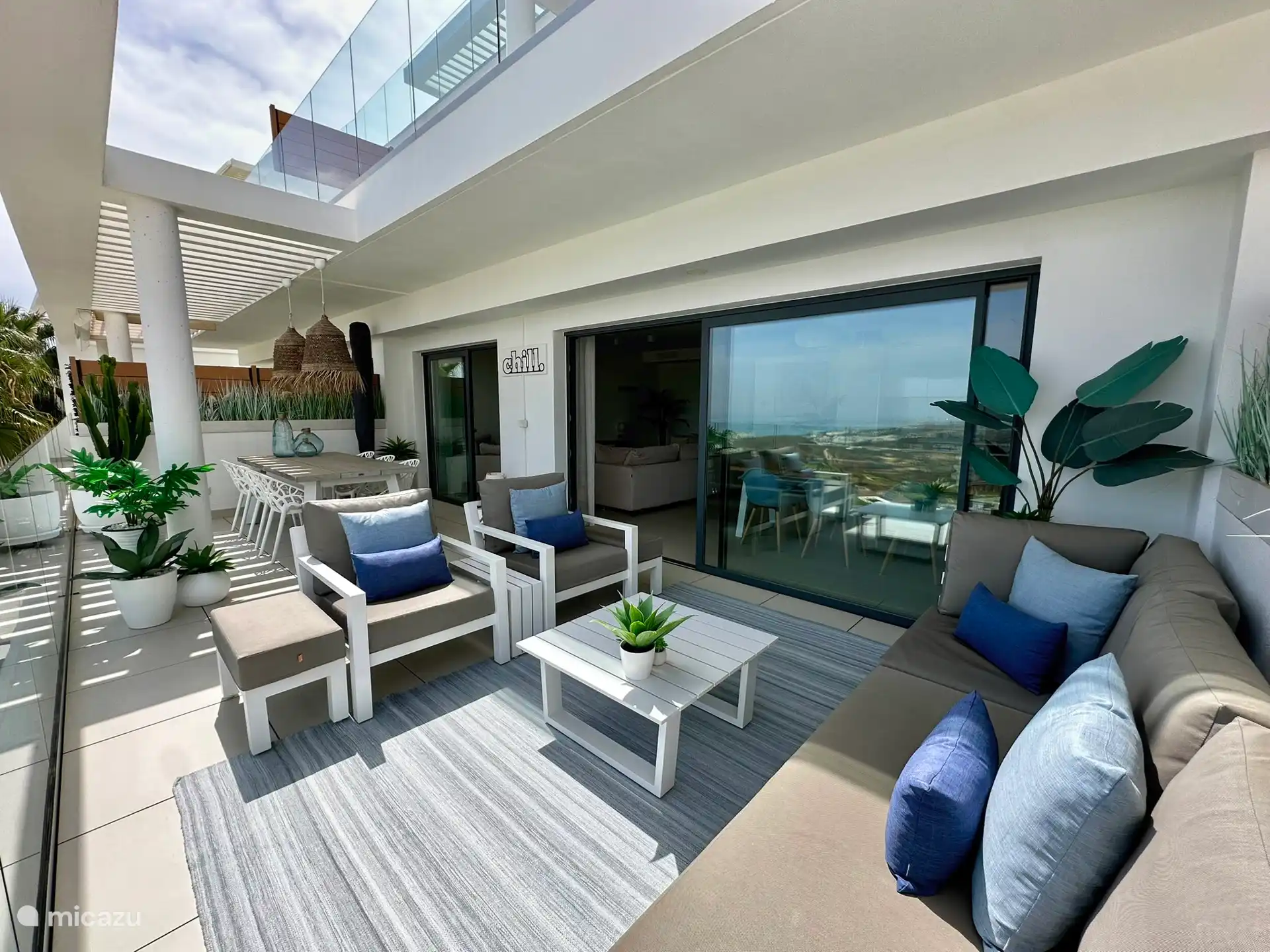 terrasse spacieuse et chaleureuse, avec un coin salon et une table à manger, pour en profiter pleinement à tout moment de la journée