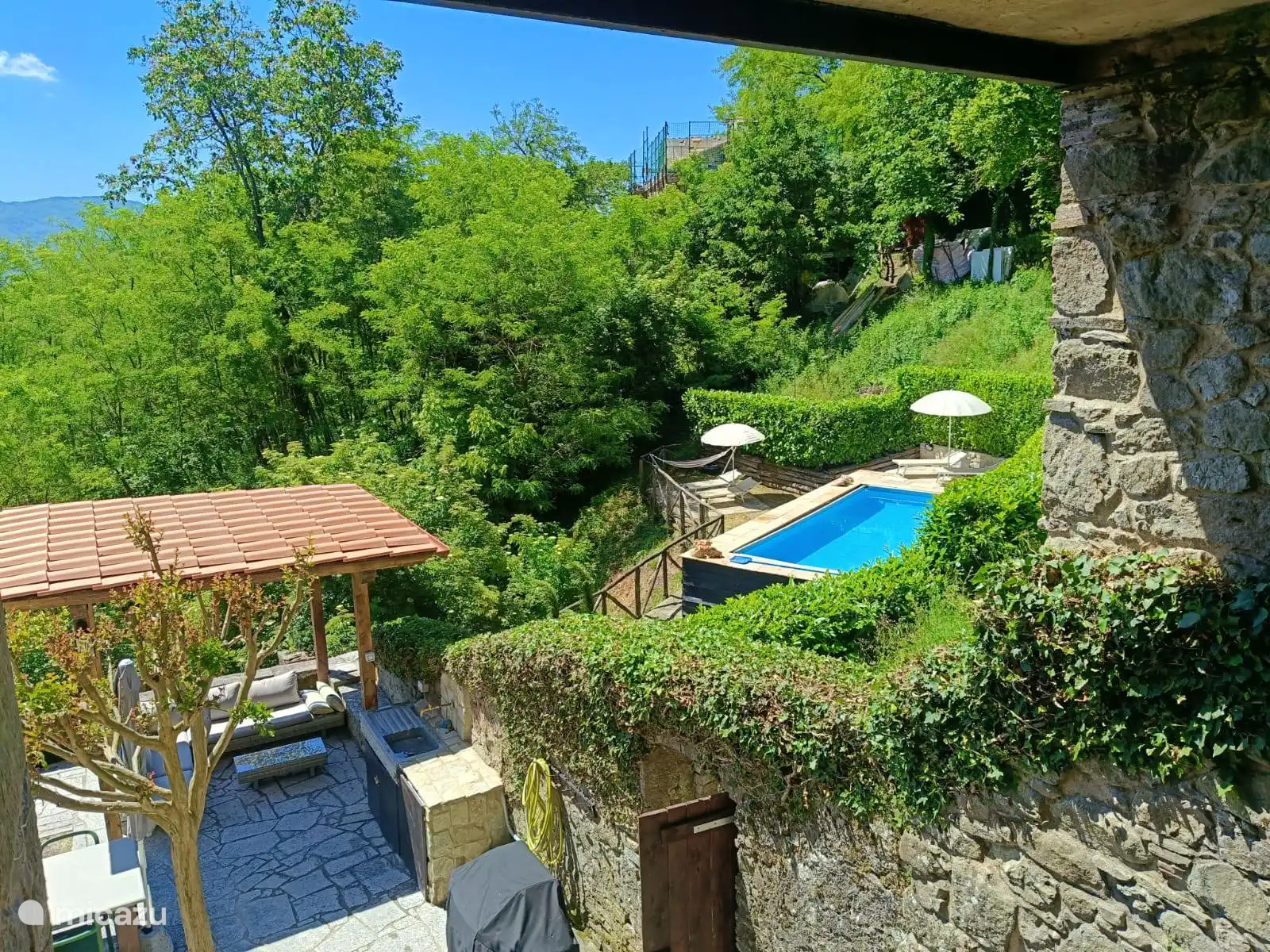 Een blik op onze tuin (met gazebo gemaakt in mei 2025) en het zwembad (gebied).