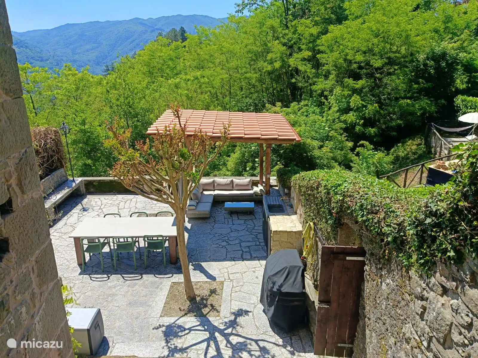 Onze tuin, met gazebo, loungeset, eettafel met 6 stoelen, een Weber gas BBQ en een buitenkeuken (water, elektriciteit en een koelkast).