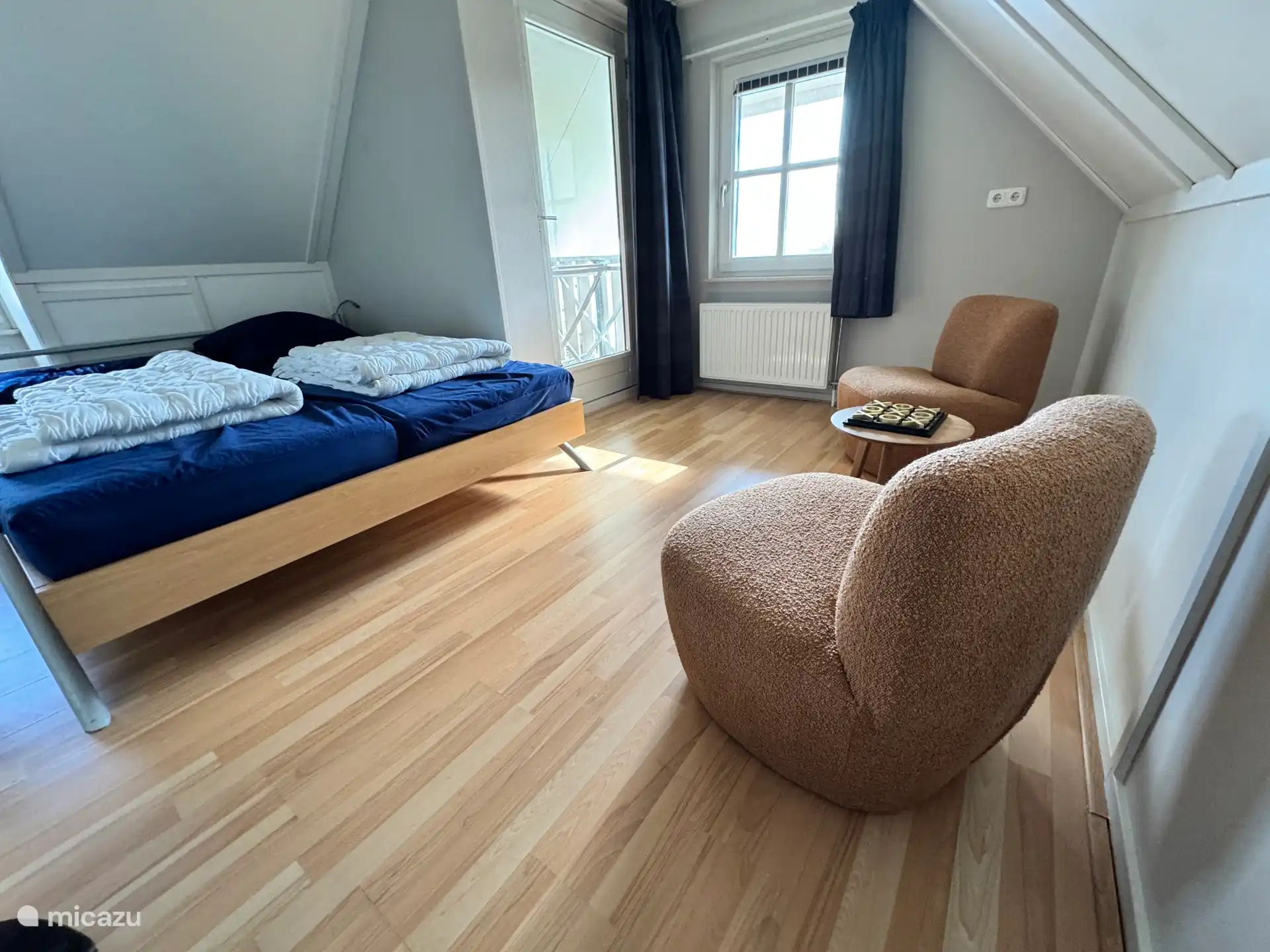 Das geräumige Schlafzimmer mit Doppelbett verfügt über eine gemütliche Sitzecke. Wunderbar, ein Buch zu lesen. Sie haben Zugang zum Balkon durch die Terrassentür, wo sich ein Wäscheständer befindet.