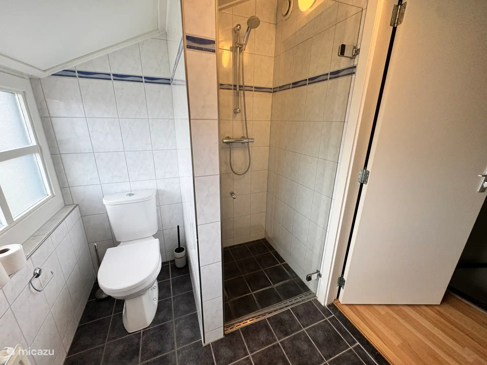 Das Badezimmer befindet sich im 1. Stock. Die ebenerdige Dusche ist geräumig. Neben der ebenerdigen Dusche befindet sich eine Toilette.