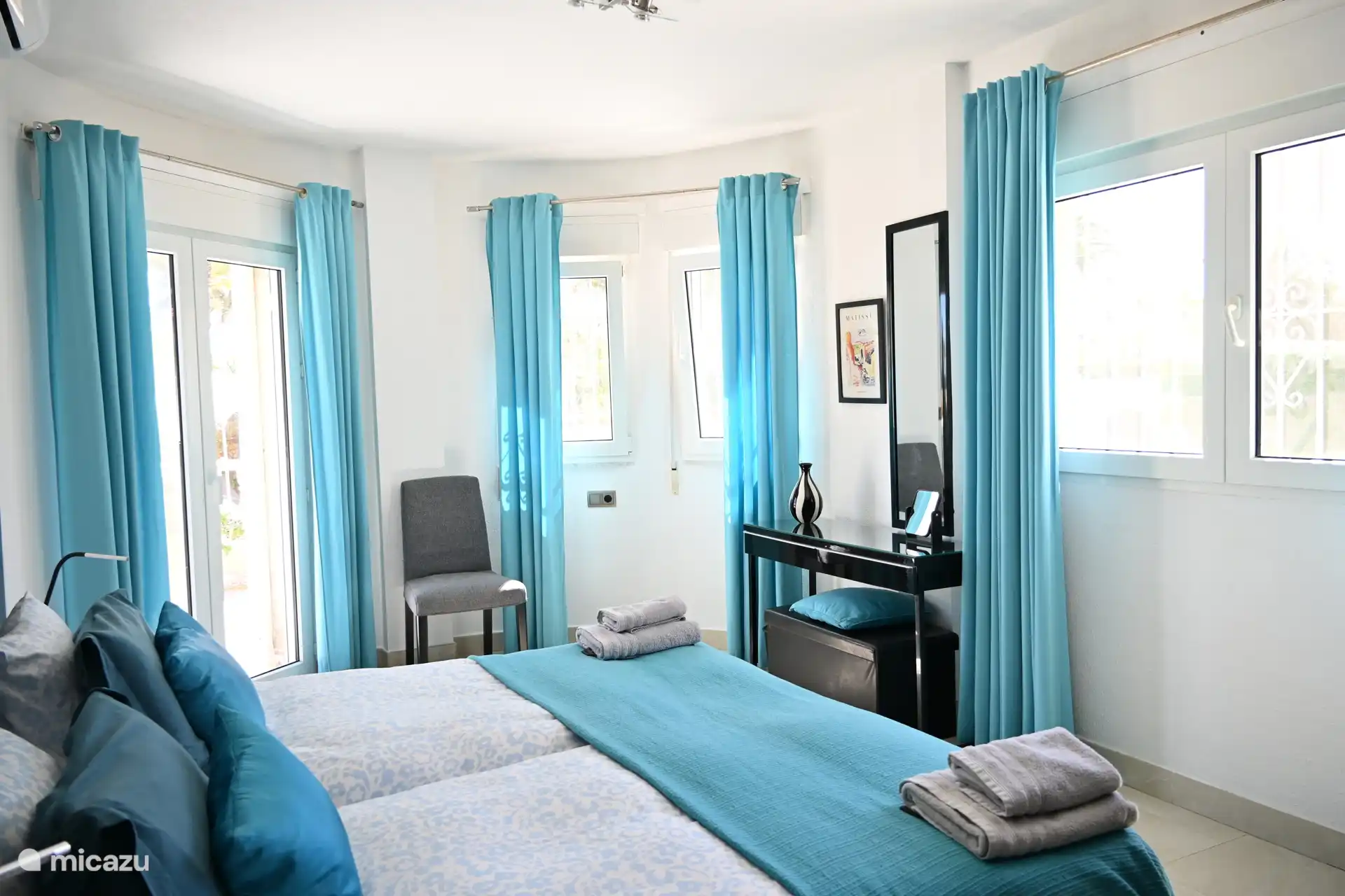 Dormitorio azul con puertas de patio que dan a la terraza