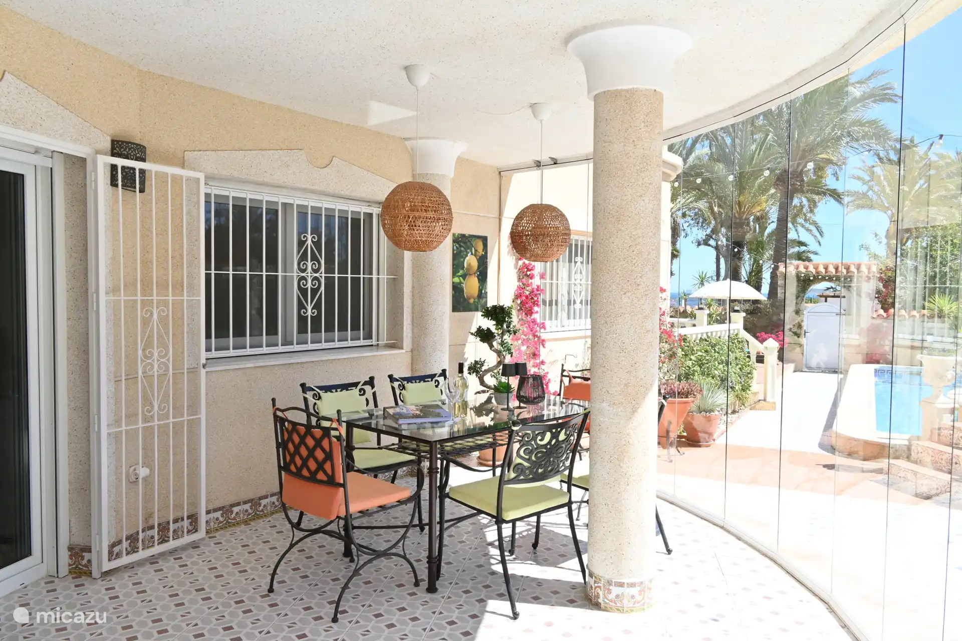 Terraza cubierta con mesa de comedor (nota: cortina de cristal ausente en verano)