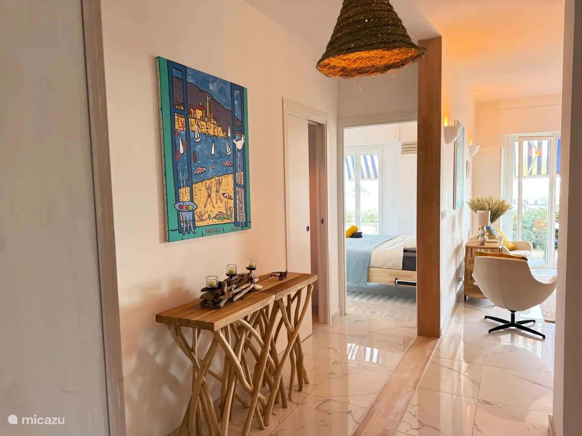 entrance hall with a bathroom on the left and the 2nd bedroom on the left and the master bedroom straight ahead and the living room with kitchen on the right