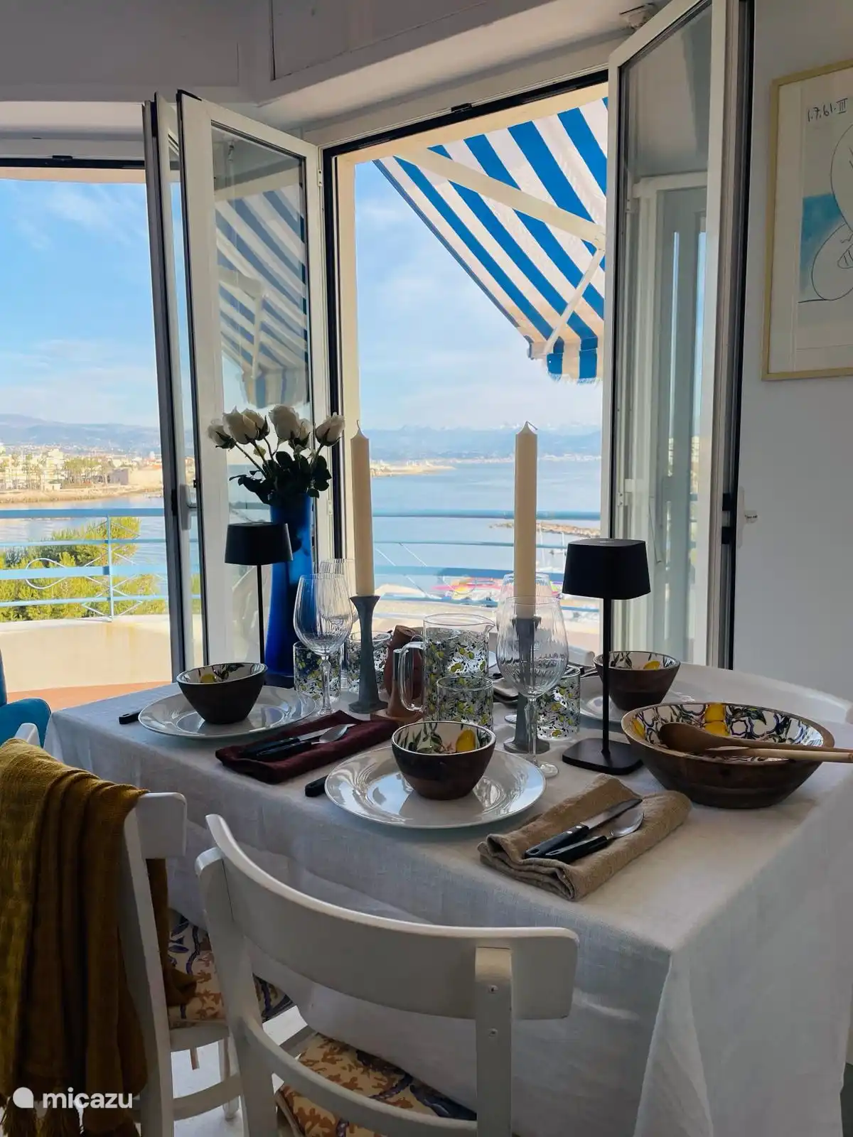 dinner table with 3 patio doors to the surrounding roof terrace with sea views and old Antibes town.