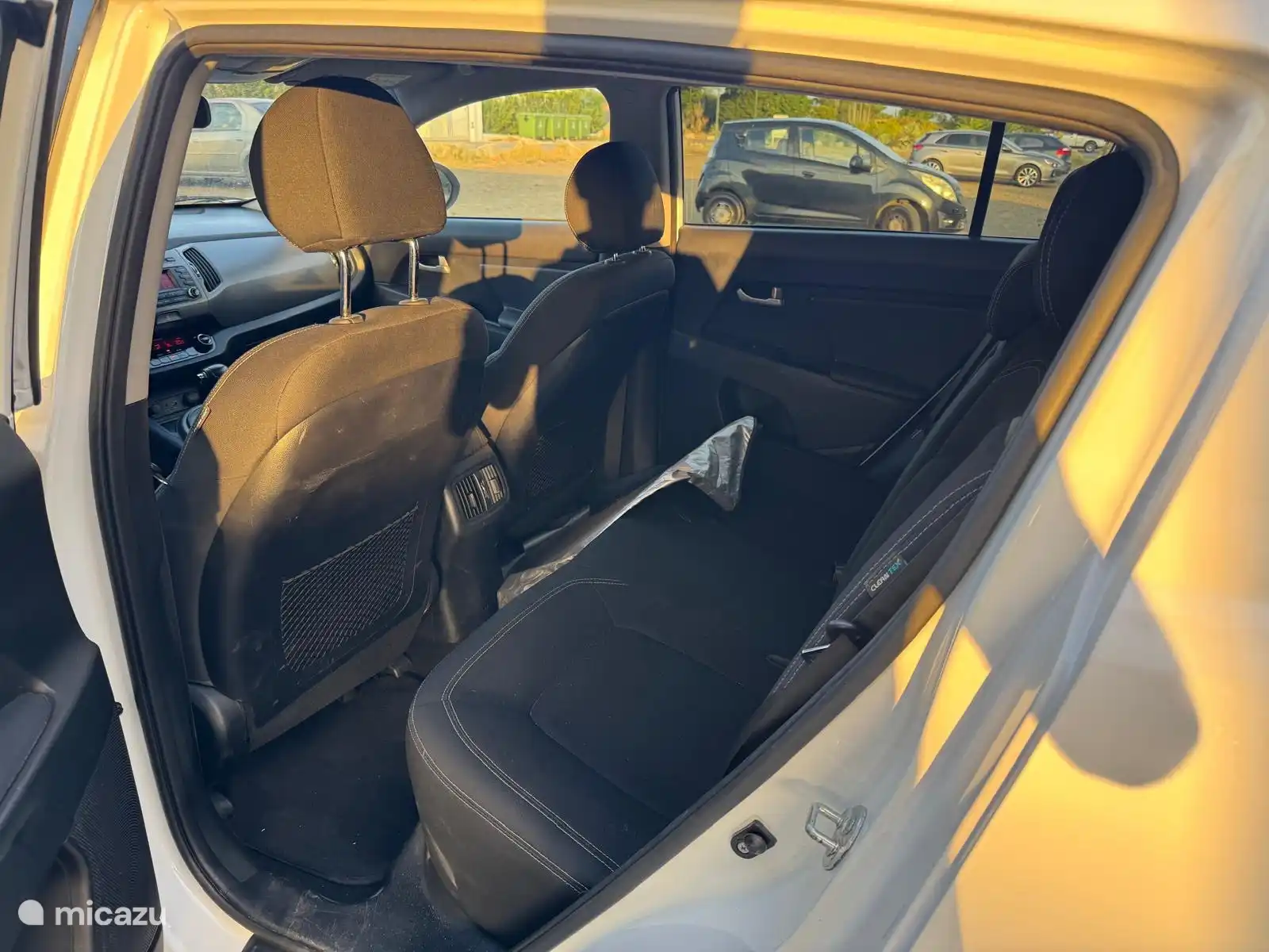 Die geräumige Rückbank unseres Leihwagens - ein weißer Kia Sportage Automatik. Der Einfachheit halber steht ein Sonnenschutz hinter dem Fenster zur Verfügung, wenn das Auto steht.