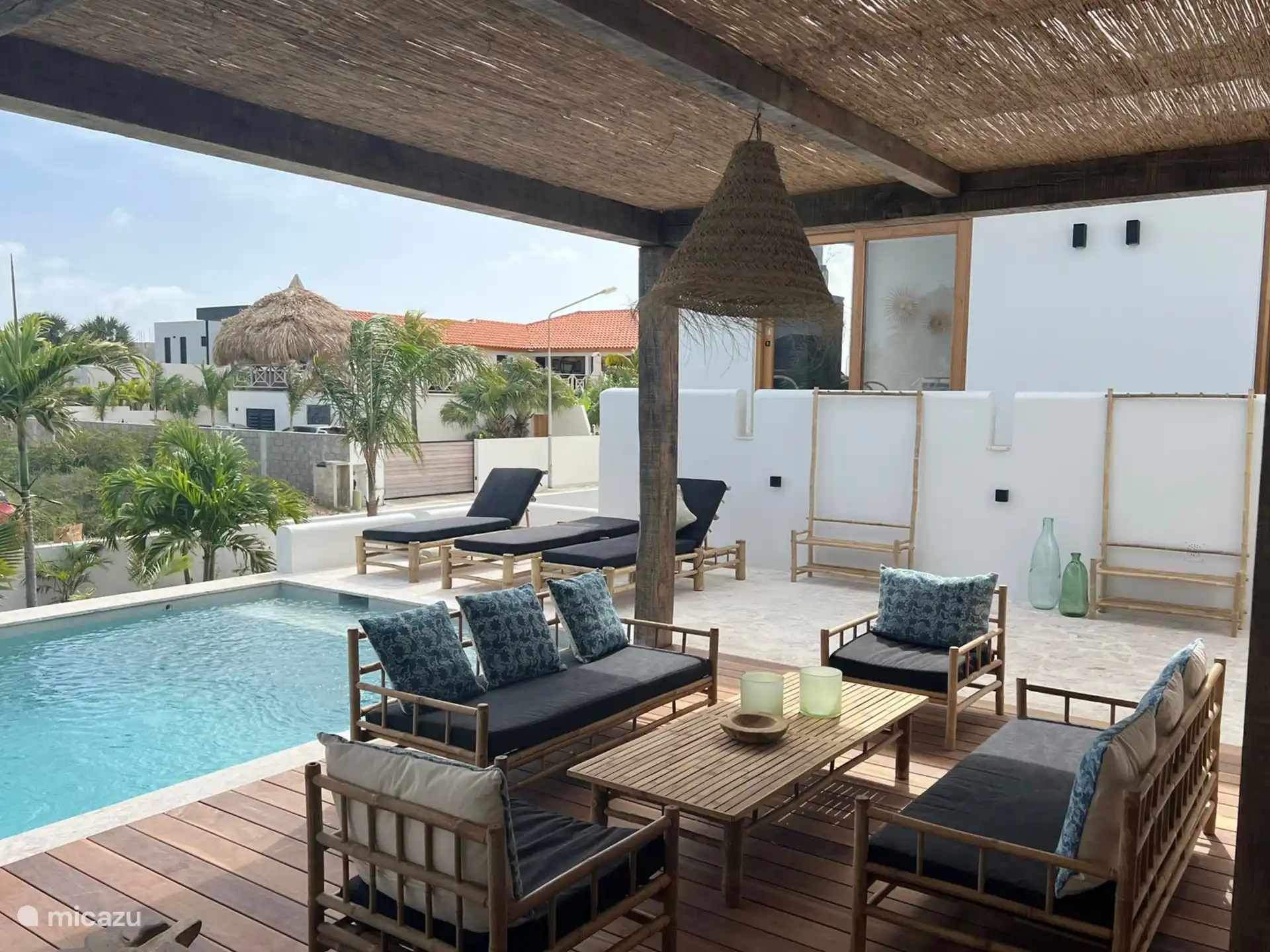 Heerlijk terras met loungeset en ligstoelen nabij het zwembad.