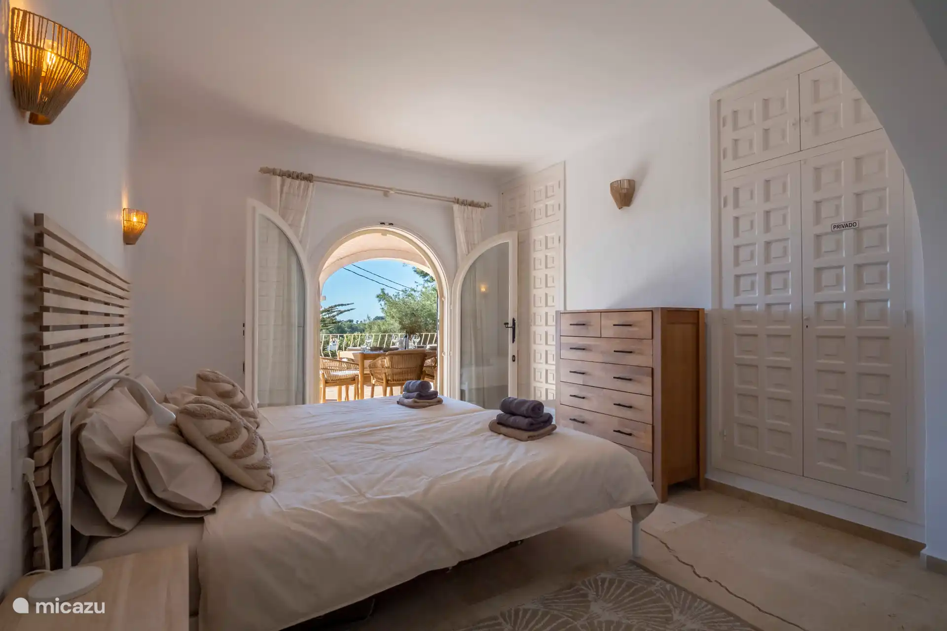 Schlafzimmer 1 mit Doppelbett und Terrassentüren zum überdachten Naya.