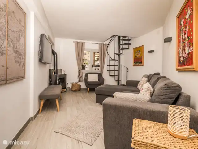 Casa au Lilas Rosa | Espagne, Costa Blanca, Benissa - villa Salon au rez-de-chaussée avec poêle à bois, télévision à écran plat, canapé-lit et escalier en colimaçon menant à d’autres chambres avec salle de bains privative (Veni, Vidi, Vici).