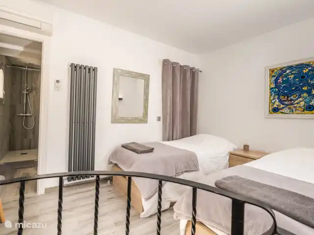 Casa au Lilas Rosa | Espagne, Costa Blanca, Benissa - villa Veni, Vidi, Vici, chambre avec salle de bains privative avec 2 lits simples ou 1 lit super king size.  On y accède par l’escalier en colimaçon dans le salon ou par la salle de bain du deuxième étage.  Dispose d’une petite armoire intégrée et d’une commode. Literie et serviettes fournies.