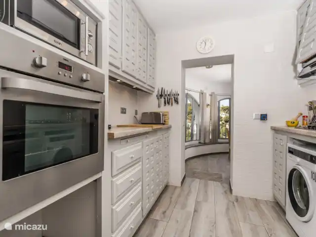 Casa au Lilas Rosa | Espagne, Costa Blanca, Benissa - villa A l’étage galerie cuisine avec lave-vaisselle, four, plaque de cuisson, machine à café nespresso, lave-linge, casseroles et poêles.  Accès à la salle à manger à l’étage et au réfrigérateur-congélateur de style américain.