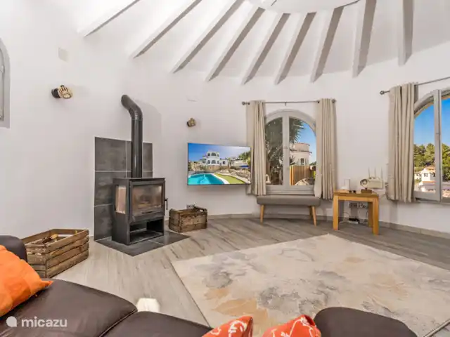 Casa au Lilas Rosa | Espagne, Costa Blanca, Benissa - villa Salon à l’étage avec poêle à bois, télévision à écran plat, canapés, chaises et vue sur la vallée, la piscine et les terrasses inférieures.