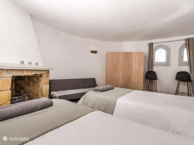 Casa au Lilas Rosa | Espagne, Costa Blanca, Benissa - villa Carpe Diem - la plus grande chambre de La Casa avec soit 2 lits simples, soit 1 lit super king size.  Grande armoire, cheminée décorative et canapé-lit.  Vue sur la piscine.  Au rez-de-chaussée et accessible depuis la cuisine du rez-de-chaussée et la petite salle de petit-déjeuner intérieure.  Literie et serviettes fournies.