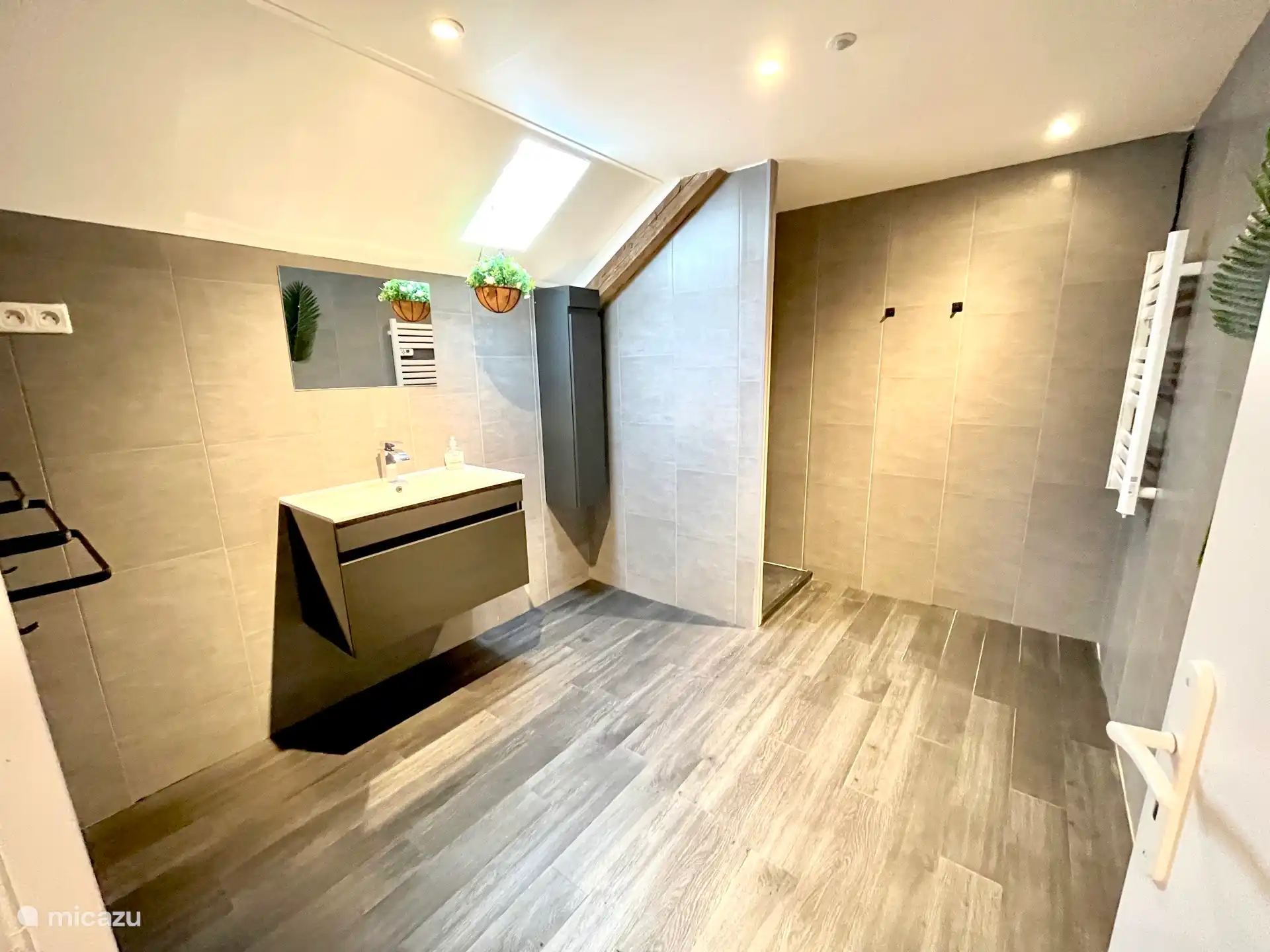 Salle de bain spacieuse au rez-de-chaussée avec douche à l’italienne / pluie, lavabo, sèche-cheveux et armoire à colonnes.