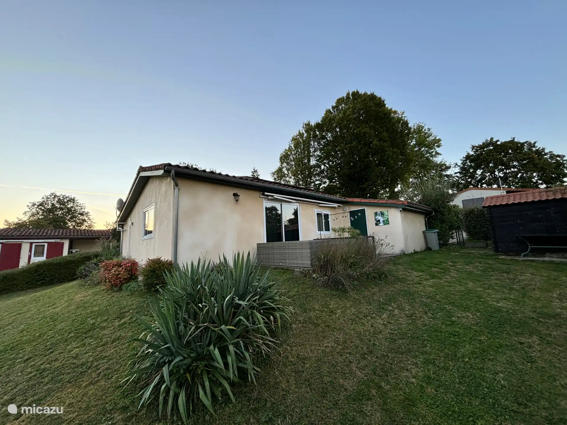 Hoofdterras achterzijde met loungebank en buiteneettafel met 6 stoelen.