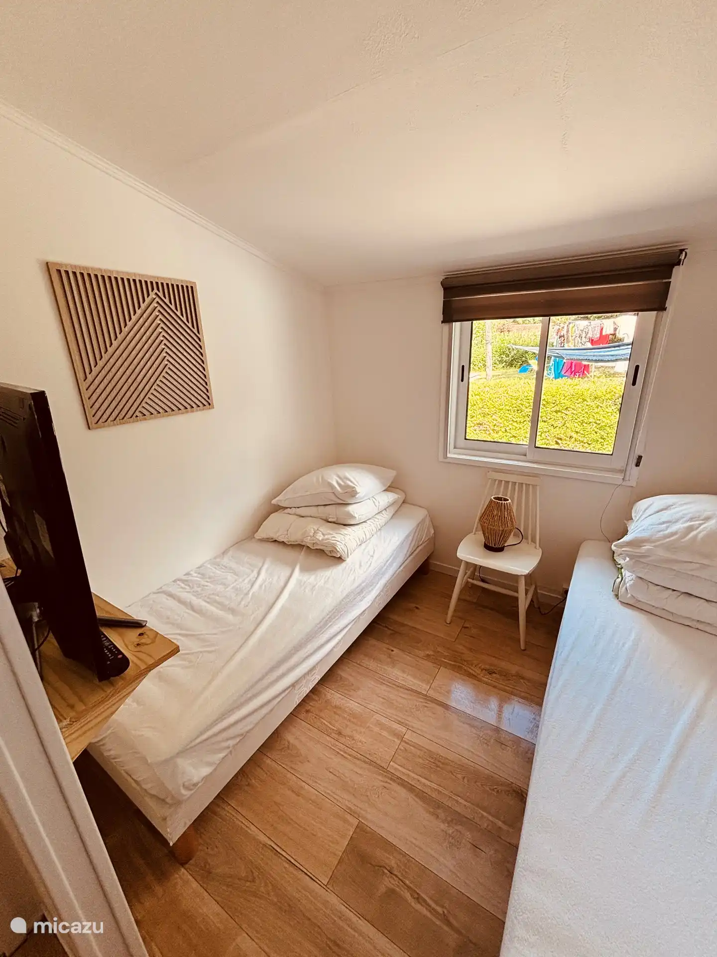 Tweede slaapkamer voorzien van eigen wastafelmeubel, TV met chromecast en airco.