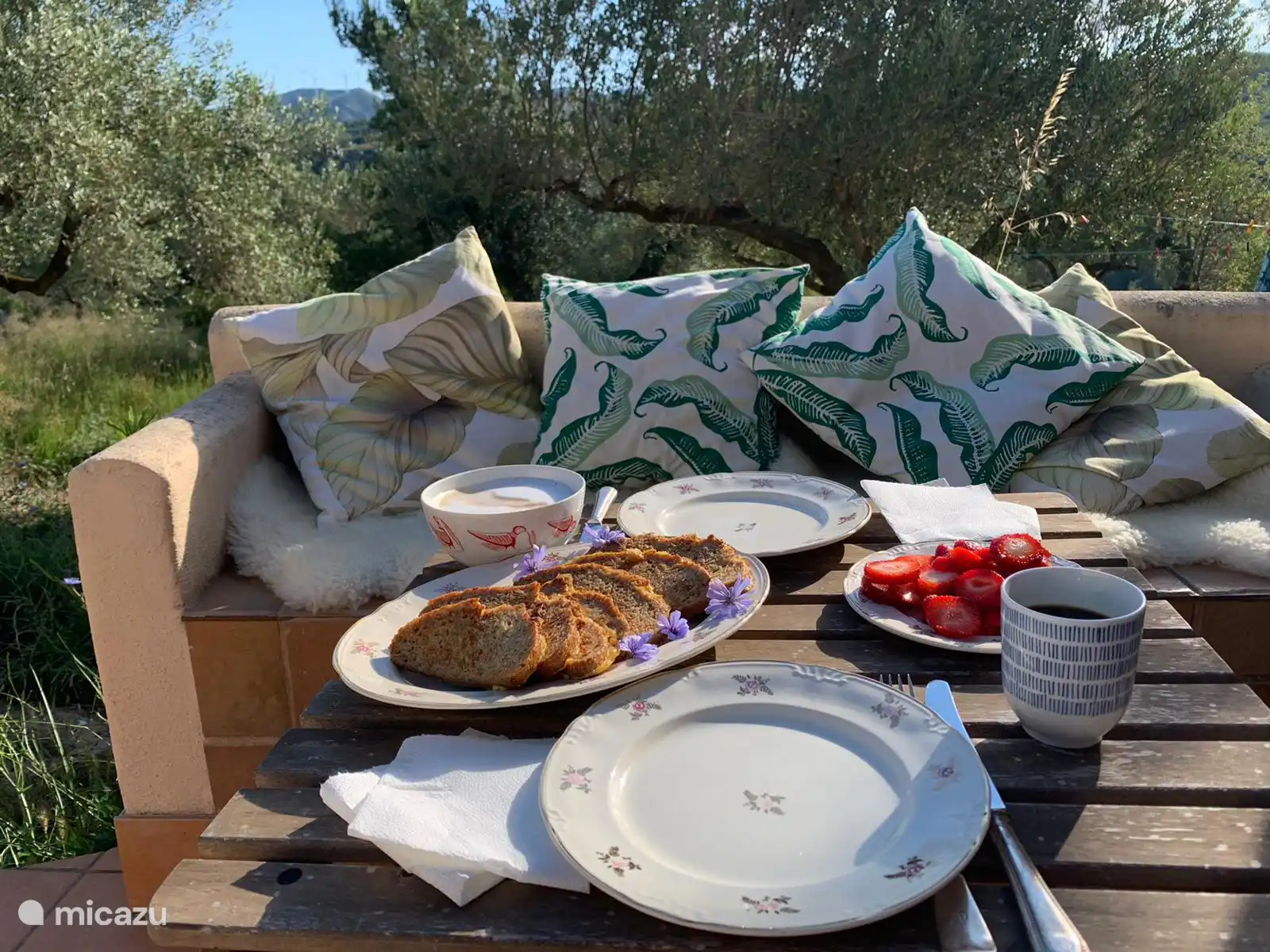 Notre terrasse à l’avant de la maison joliment décorée avec des oreillers et des fourrures et de délicieuses collations du marché.