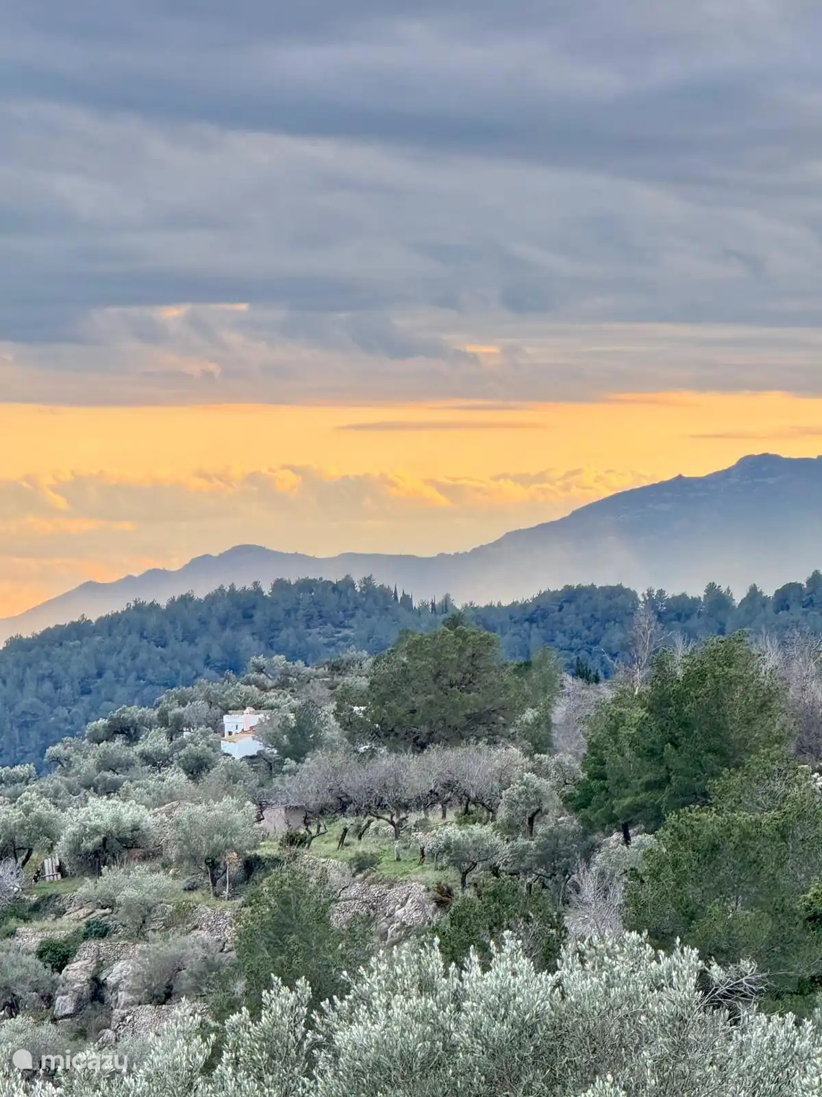 En revenant, nous voyons notre maison contre le soleil couchant.