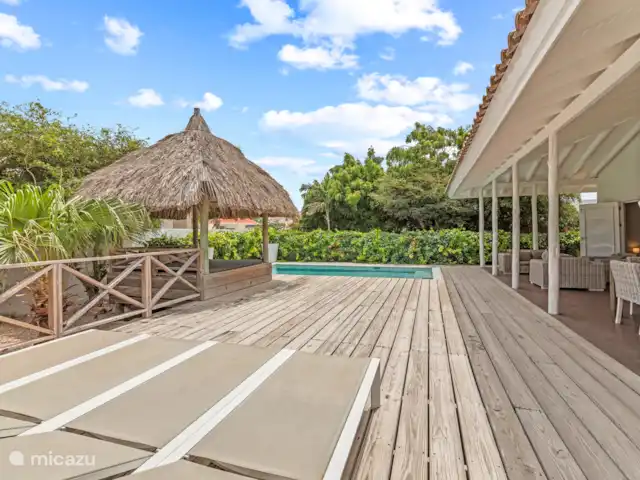 Villa Solaya 1, Jan Thiel | Curaçao, Banda Ariba (est), Jan Thiel - villa Lorsque vous conduisez dans le jardin, vous entrez dans le paradis. Des fleurs colorées, des palmiers qui se balancent, une piscine avec des transats, une palapa, un joli salon et une grande table à manger à l’extérieur sous le bord