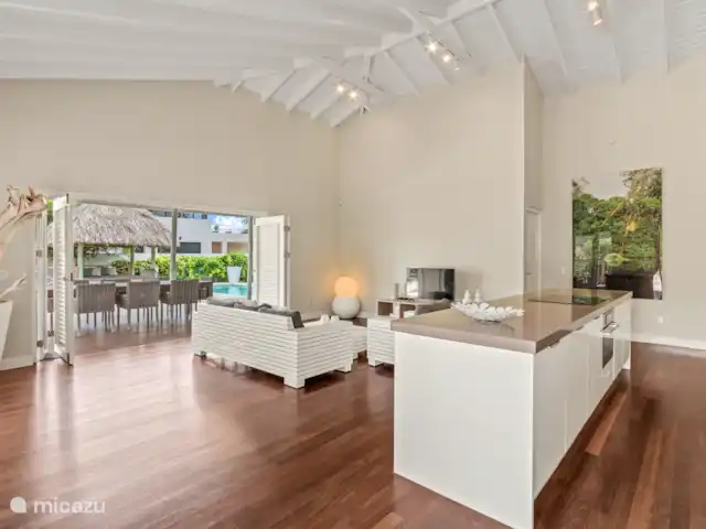 Villa Solaya 1, Jan Thiel | Curaçao, Banda Ariba (est), Jan Thiel - villa Salon tropical avec hauts plafonds, portes-fenêtres et cuisine ouverte. La maison vous donne la vraie sensation d’intérieur-extérieur.