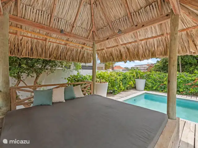 Villa Solaya 1, Jan Thiel | Curaçao, Banda Ariba (est), Jan Thiel - villa Lorsque vous conduisez dans le jardin, vous entrez dans le paradis. Des fleurs colorées, des palmiers qui se balancent, une piscine avec des transats, une palapa, un joli salon et une grande table à manger à l’extérieur sous le bord