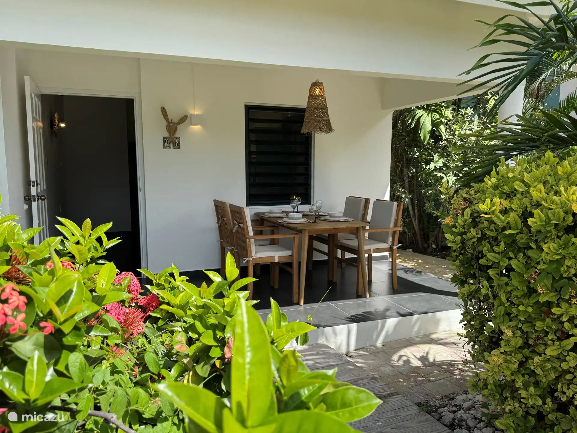 La véranda confortable à l’avant avec une table à manger avec 4 chaises. 