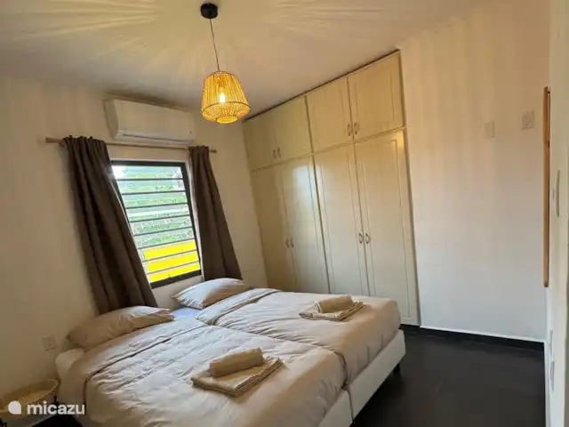 Location de Vacances Curaçao, Banda Ariba (est), Jan Thiel, maison de vacances - Casita Apapacho Puru Jan Thiel  2ème chambre avec deux lits séparés avec sommier tapissier (90x200) avec couettes séparées (140x210) qui peuvent également être attachées l’une à l’autre comme un lit double. Climatisation, miroir et armoire encastrée avec suspension et pose.