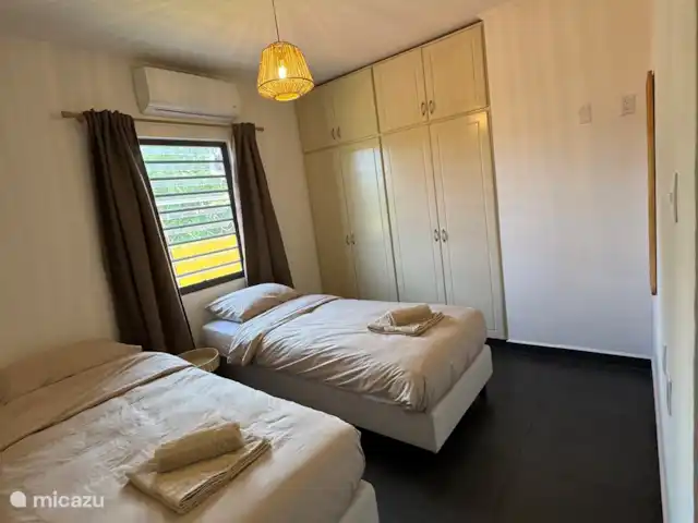 Location de Vacances Curaçao, Banda Ariba (est), Jan Thiel, maison de vacances - Casita Apapacho Puru Jan Thiel  2ème chambre avec deux lits séparés avec sommier tapissier (90x200) avec couettes séparées (140x210) qui peuvent également être attachées l’une à l’autre comme un lit double. Climatisation, miroir et armoire encastrée avec suspension et pose.